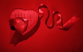Gift with a ribbon on a red background for Valentine's Day February 14