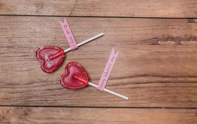 Two red lollipops for a loved one on a wooden table