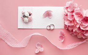 White wedding invitation with flowers on pink background