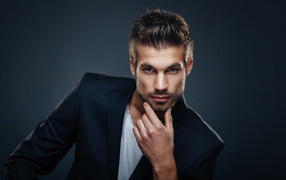 Handsome stylish man in jacket on gray background