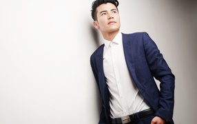 Male model in suit against a white wall