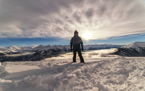 Man in the snow-capped mountains in the sun