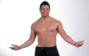 Smiling muscular man on gray background
