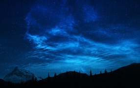 Красивое ночное небо над заснеженной горой