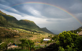 Large multicolored rainbow in the sky over the mountains