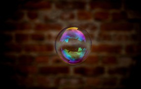 Мыльный пузырь в воздухе на фоне стены