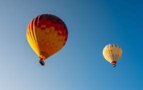 Two big colorful balloons in the blue sky