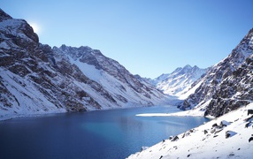 The lake in the snow-capped mountains under the blue sky