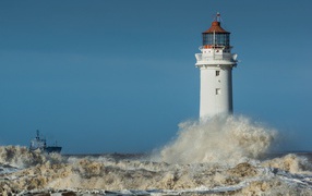 Raging white waves hitting the lighthouse