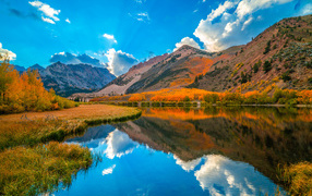 Beautiful autumn mountain landscape under the blue sky by the lake