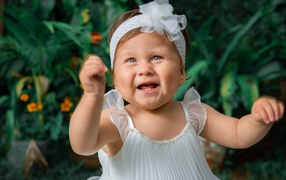 Красивая маленькая девочка в белом платье 