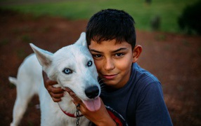 Мальчик с белой собакой с голубыми глазами 