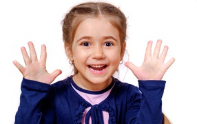 Cheerful little girl with raised hands