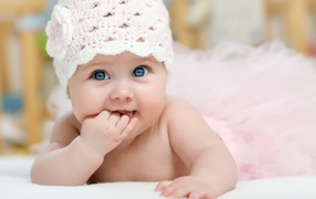 Милая голубоглазая малышка в розовой шапке 