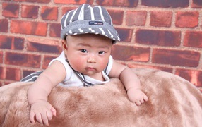 Little asian child on wall background