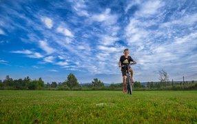 Little boy riding a bicycle on the field