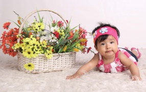 Little girl next to a basket of flowers