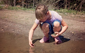 Little girl playing in a puddle