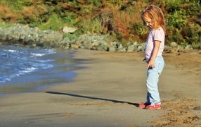 Little girl walking on wet sand