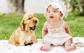 Маленькая девочка с щенком на поляне
