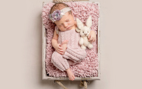 Маленькая новорожденная девочка спит в ящике 