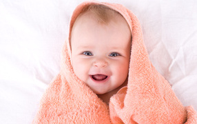 Smiling nursing baby in a towel