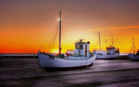 Fishing boat on the shore at sunset