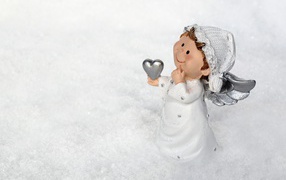 Статуэтка ангел стоит на снегу 