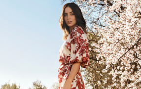 Actress Ana de Armas against the background of a blossoming tree