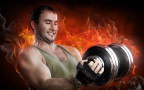 Inflated man with dumbbells in his hands against the background of fire