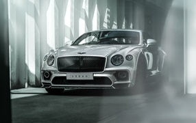 Серебристый автомобиль Bentley Continental GT в здании
