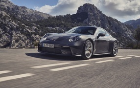 Автомобиль Porsche 911 GT3 Touring 2023 года на фоне гор