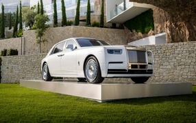 Белый автомобиль Rolls-Royce Phantom 2022 года у дома