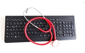 Black keyboard with stethoscope on white background