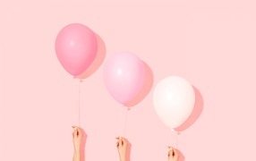 Три воздушных шарика на розовом фоне в руках