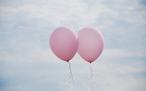 Two pink balloons in the sky