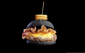 Black hamburger with juicy patty and bacon