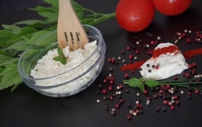 Cottage cheese on the table with parsley and tomatoes