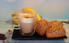 Чашка какао на столе с булочками и бананами
