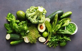 Свежие зеленые овощи на сером столе