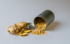 Ground ginger with root on a gray background