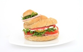 Hamburger with sausage, tomatoes and lettuce on a white background