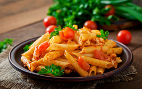 Pasta on a plate with tomatoes and parsley