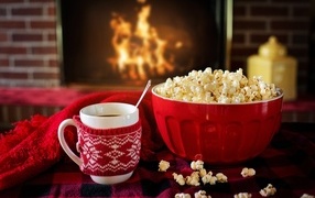 Popcorn with hot coffee by the fireplace