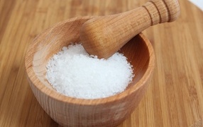 Salt in a wooden mortar on the table