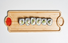 Sushi on a wooden board with red caviar