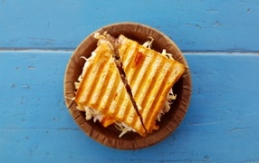 Two sandwiches on a plate on a blue table