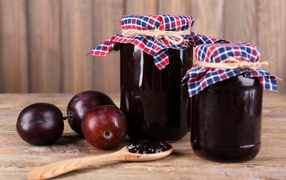 Two jars of jam on the table with plums