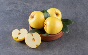Желтые осенние яблоки на сером столе