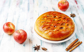 Beautiful pie on the table with apples and cinnamon